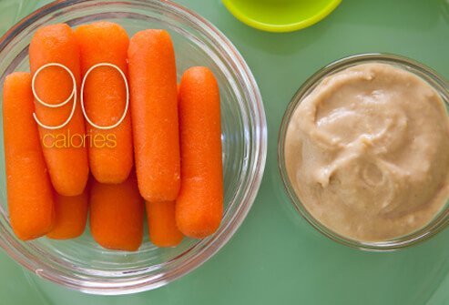 Baby carrots with a side of hummus dip.