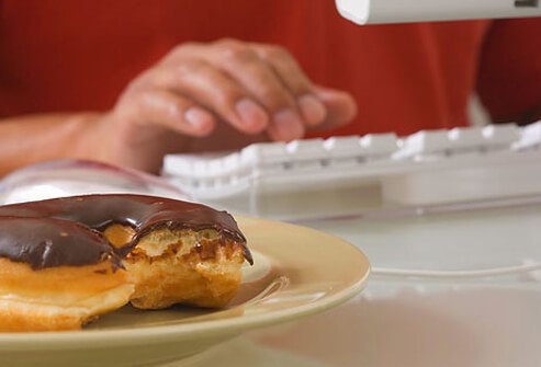 A chocolate doughnut with a bite taken out of it.