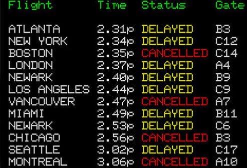Airport sign displaying delayed and cancelled flights.
