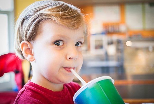 Boy toddler is drinking soda.
