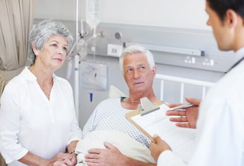 A doctor explains cancer treatment options to a couple in the hospital.