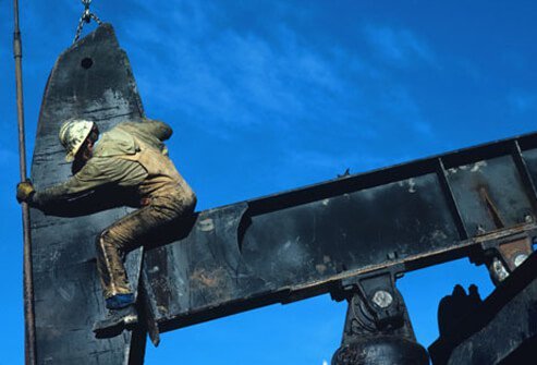 Photo of a man working on an oil pump.