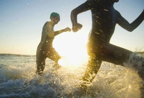 Photo of two people running in the ocean.