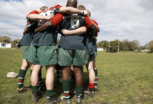 Rugby players form a huddle.