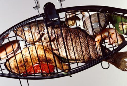 Photo of seafood in grill cage.