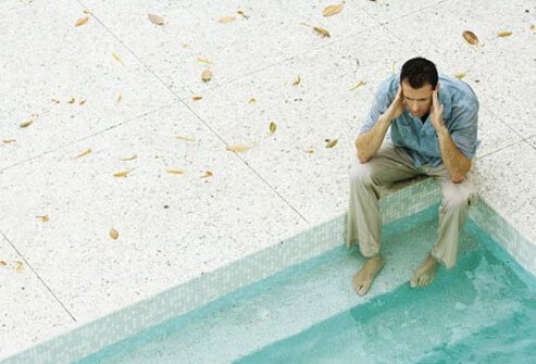 Photo of man with feet in pool.