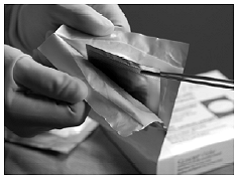 Remove the inner pouch by grabbing hold of the crimped edge of the inner pouch using a sterile instrument and pulling upward - Illustration Remove the inner pouch by grabbing hold of the crimped edge of the inner pouch using a sterile instrument and pulling upward - Illustration