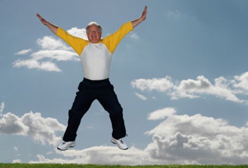A senior man jumps in the air.