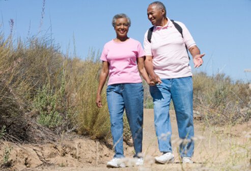 A senior couple on a walk through the countryside.