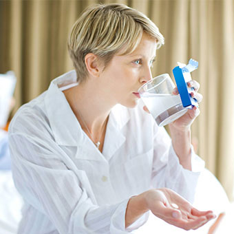 A woman takes antacids for stomach pain.