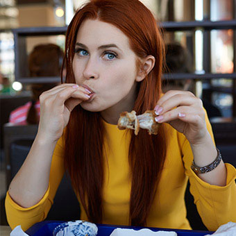 A woman eating a lot of food fast.