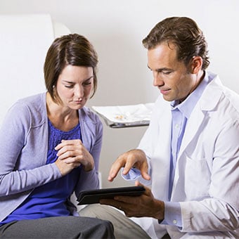 A doctor explains skin conditions that can mimic hives to a patient.