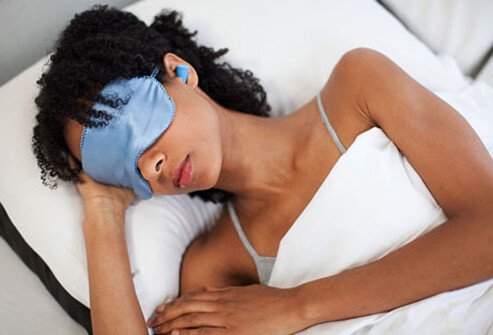 Photo of a woman sleeping in mask and earplugs.