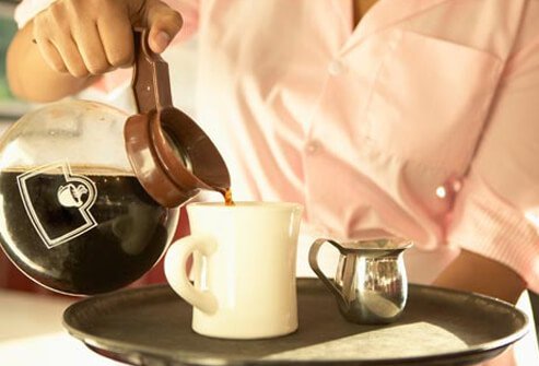 A server pours a cup of coffee.