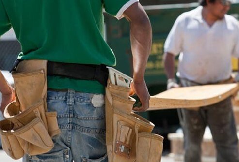 Carpenters lift wooden beams.