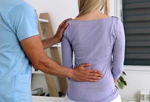 Picture of a healthprofessional with his hand on a patien'ts lower back. Picture of a healthprofessional with his hand on a patien'ts lower back.