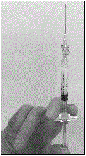 Keep the syringe UPRIGHT. With the opposite hand pull the needle cap upward - Illustration
