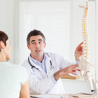 A doctor and patient discuss part of the spine.