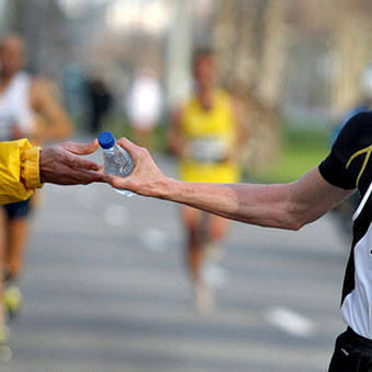 A runner takes a bottle of water during a race.