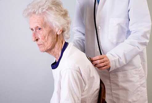 A senior woman with osteoporosis is examined by her doctor.