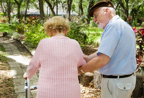 A senior couple with osteoporosis goes for a walk.