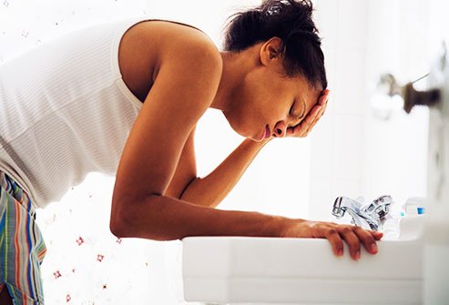 Pregnant woman bending over a sink. Pregnant woman bending over a sink.
