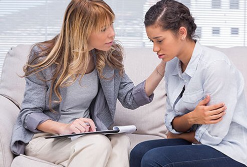 A therapist counsels a woman.