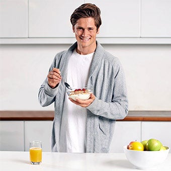 A man eats yogurt for breakfast.