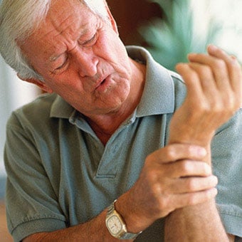 A man experiences rheumatoid arthritis (RA) joint pain in his wrist.