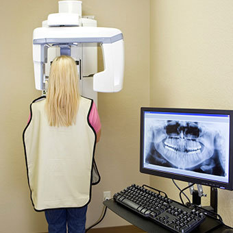 A woman wears a lead apron as she gets X-rays prior to her root canal.