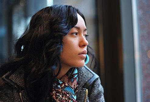 Photo of a depressed woman waiting at the train station.