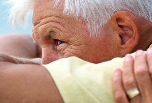 A senior man being consoled.