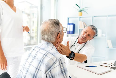 Picture of a doctor palpating an older man's throat. Picture of a doctor palpating an older man's throat.