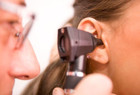A doctor examines a patient's ear for possible causes of tinnitus.