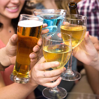 Friends toast each other with various alcohol drinks.