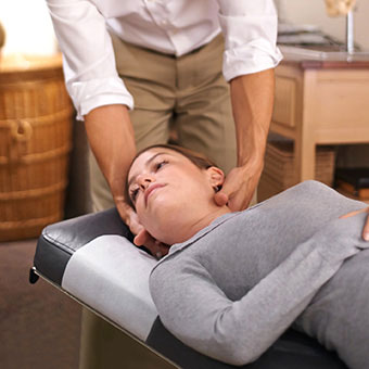 A physical therapist helps a patient with head exercises to treat vertigo.