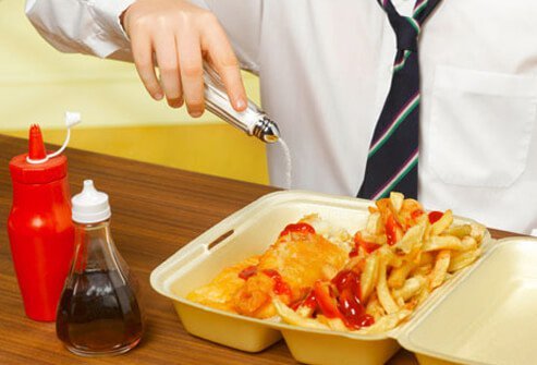 A man salting fish and chips.