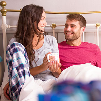 A couple having a discussion in bed.