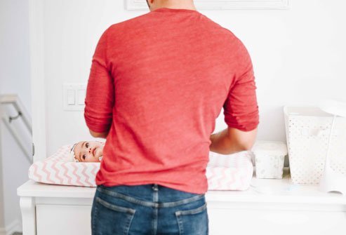 Picture of a man and a baby on a changing table.