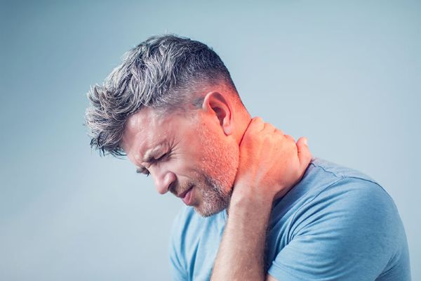 Muscular Neck Pain Person holding their neck, illustrating common muscular neck pain.